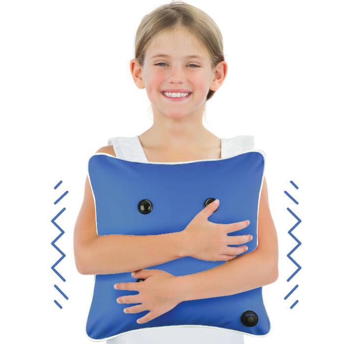 Smiling girl hugging a blue square massage cushion with black buttons and zigzag lines showing vibration.