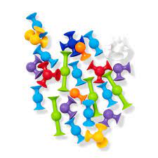 Assorted colorful suction cup building toys in various shapes scattered on a white background.