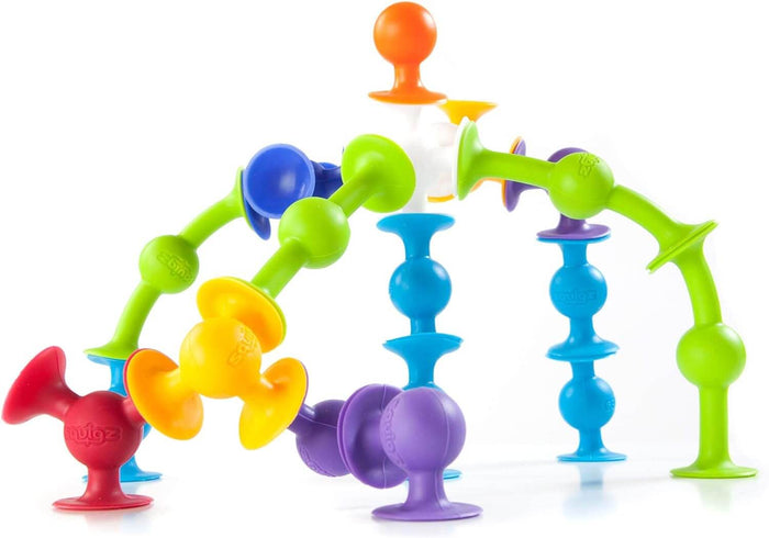 Brightly colored suction-cup building pieces connected to form a curvy, arched structure on a white background.