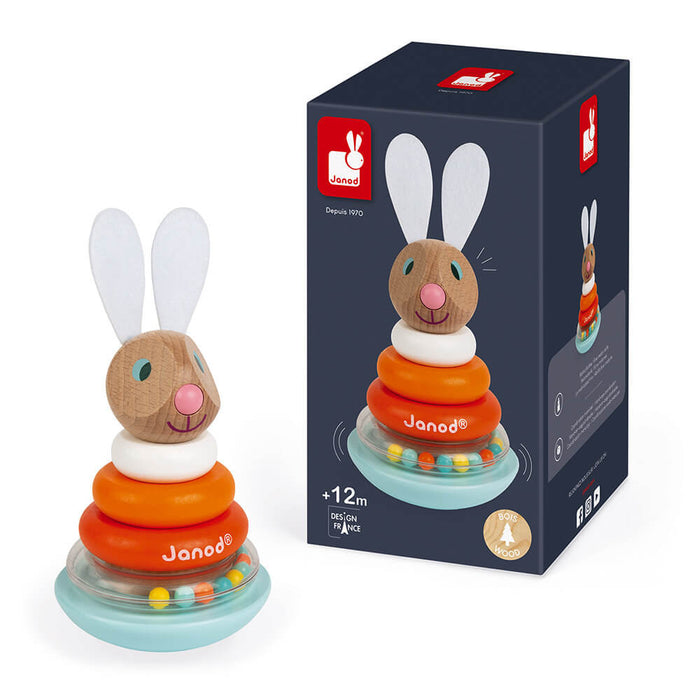 Wooden rabbit stacking toy with white ears, orange rings, and bead-filled base next to its blue packaging box.