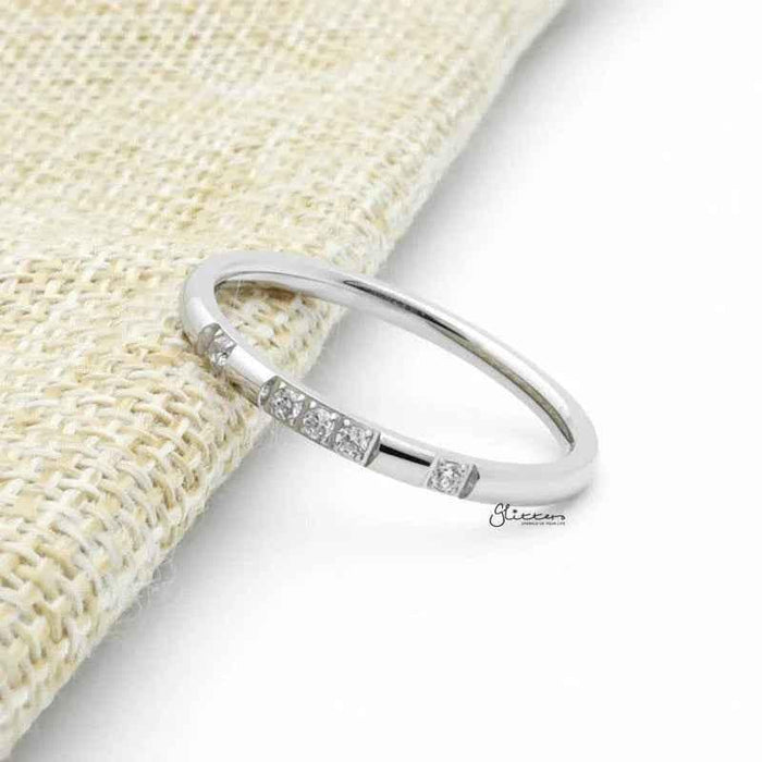 Silver stainless steel band ring with five CZ inlays, featuring a sleek design and polished finish by Glitters.