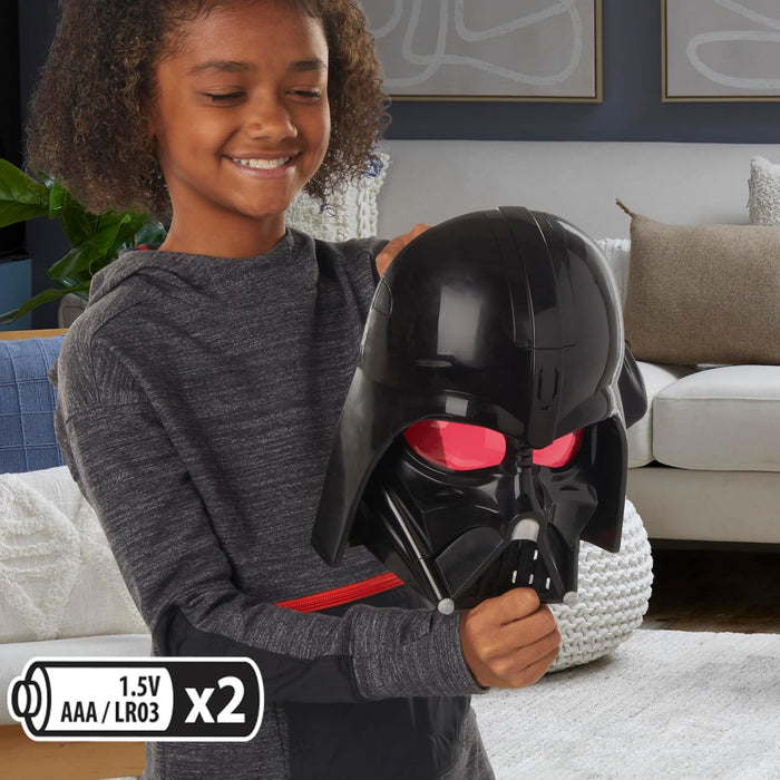 Child holds a black Darth Vader mask with glowing red eyes. Battery icon shows 2 AAA batteries required.
