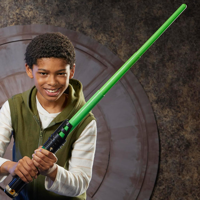 Smiling boy holding a green telescoping toy lightsaber with a black hilt and green and gold accents.