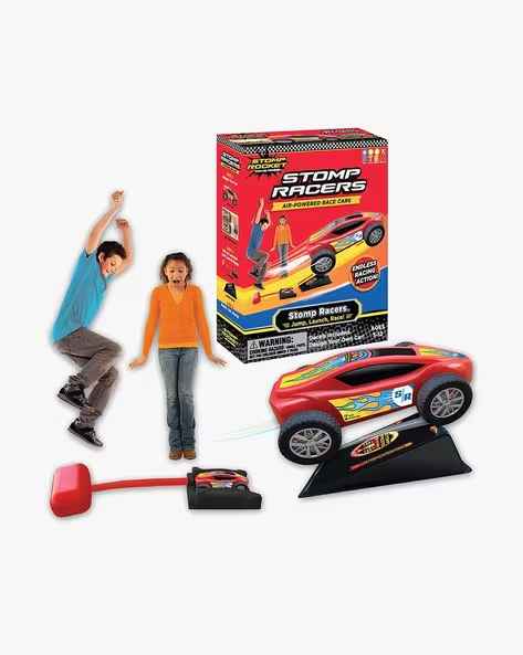 Red toy race car on a ramp with a stomp launcher and two children next to the product box.