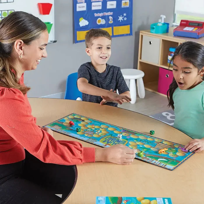 Teacher and kids play a swamp-themed board game with animal figures and dice on a colorful illustrated board.