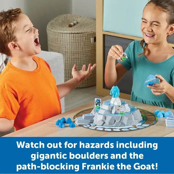 Two children play a 3D mountain board game with a blue yeti piece, character markers, and blue crystal tokens.