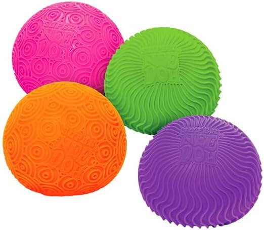 Four round squishy toys in pink, green, orange, and purple with various molded wavy and circular ripple textures.