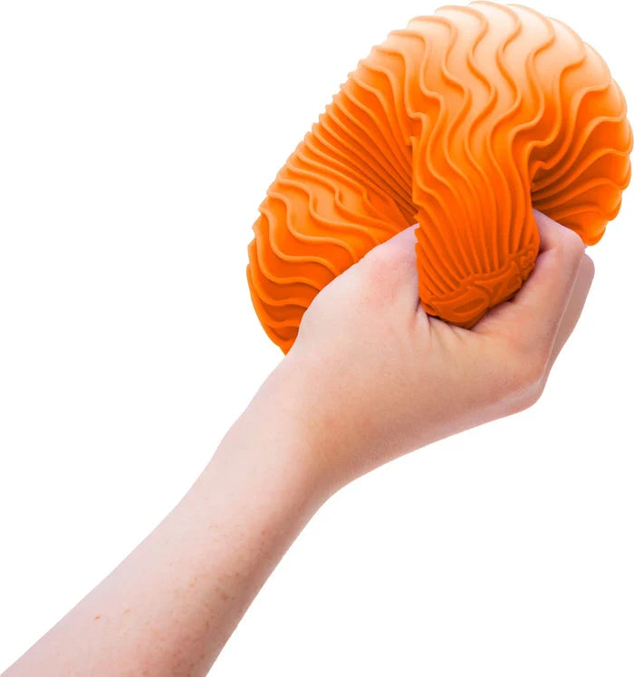 Hand squeezing a bright orange squishy ball with deep, wavy ripple textures.