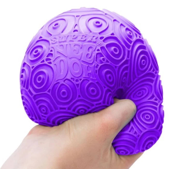 Hand squeezing a large purple squishy ball with an embossed pattern of concentric circles and ripples.