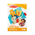 Packaging for a baby toy with a plush orange bear and ball inside a colorful, open polka-dot fabric gift box.