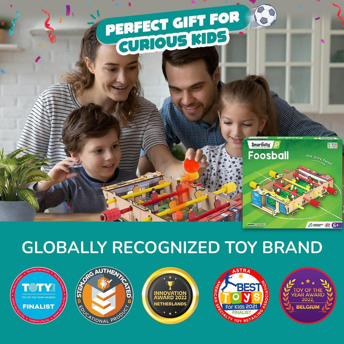 Family playing with a wooden DIY foosball game next to its green box and several international toy award badges.