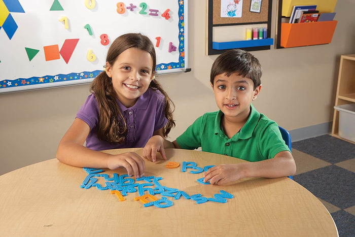 Children playing with blue and orange plastic letters featuring raised, bumpy textures for tactile learning.