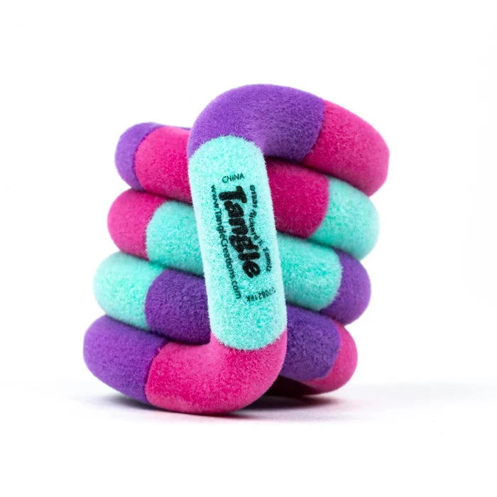Fuzzy pink, purple, and teal coiled fidget toy with soft interlocking segments on a white background.