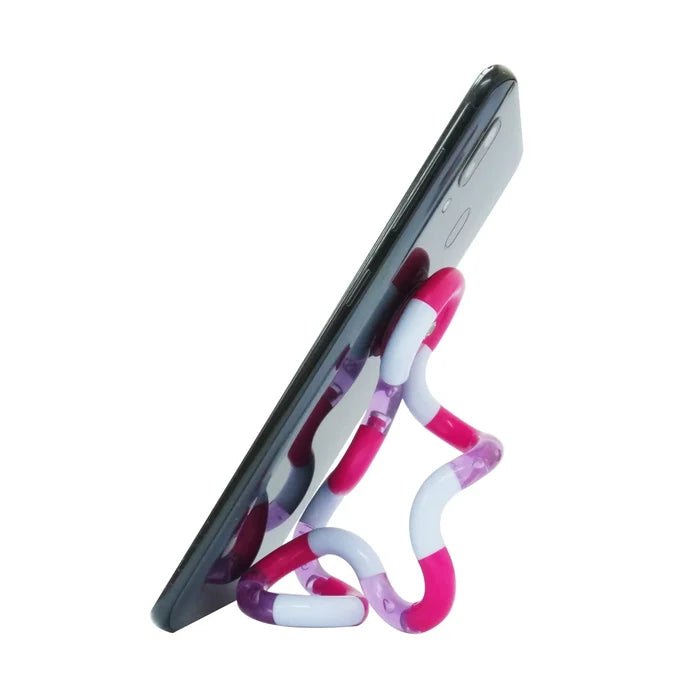 Twisted pink, white, and purple plastic fidget toy propping up a black smartphone on a white background.