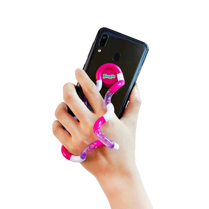Pink, white, and purple glittery jointed toy loops around a hand and attaches to the back of a black smartphone.