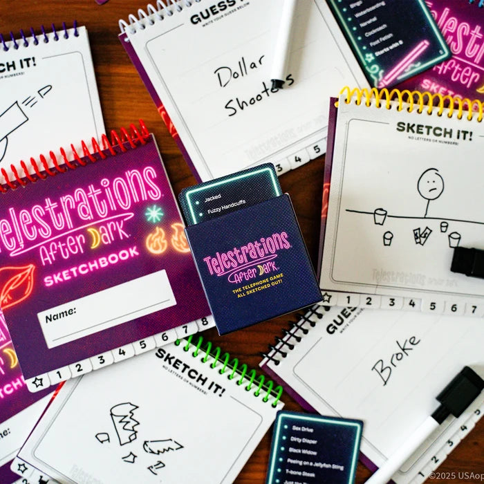 Adult party game with neon spiral sketchbooks, word cards, and dry-erase markers showing humorous hand-drawn sketches.