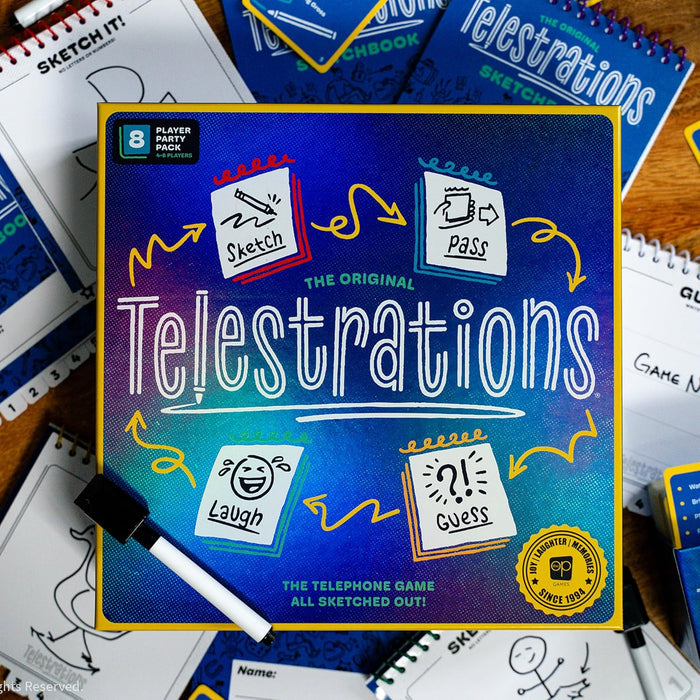 Blue Telestrations game box with yellow trim, surrounded by dry-erase markers and pads showing cartoon gameplay icons.