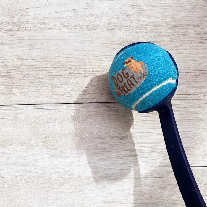 DogTreatNZ tennis ball launcher in action, showing a handheld device designed for easy and fun dog play with tennis balls.