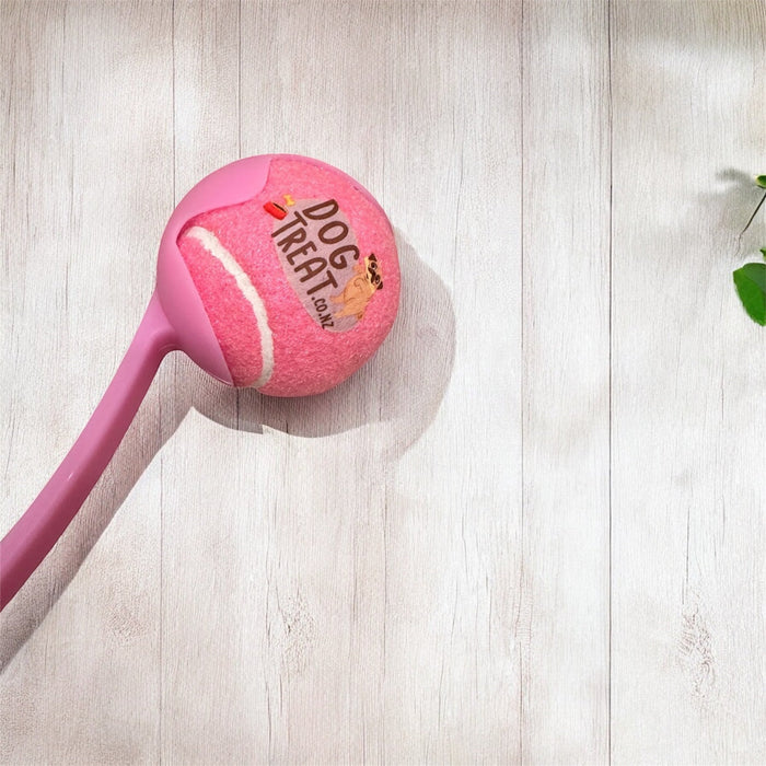 DogTreatNZ tennis ball launcher for dogs, with a sleek design and bright colors, ready to fetch and play outdoors.