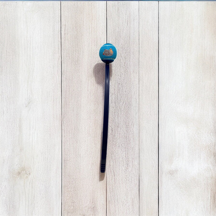 DogTreatNZ tennis ball launcher in orange, with a sleek handle and ball ready for outdoor play with a dog.
