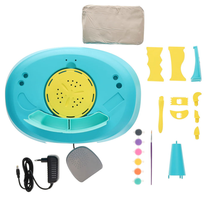 Teal and yellow toy pottery wheel kit with a foot pedal, grey clay, colorful paints, and sculpting tools.
