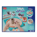 Box for Terra Studio clay kit showing a manual teal potter's wheel, clay, tools, and finished animal-themed pottery.