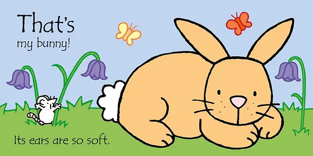 Tan bunny with a white fluffy tail in a grassy field with a mouse, butterflies, and purple bell flowers.