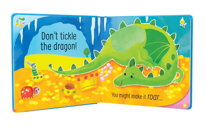 Open board book with a green dragon on gold coins, a tactile patch, and the text Don't tickle the dragon!
