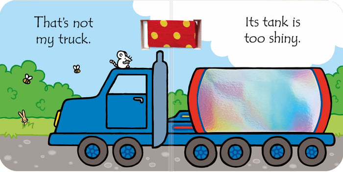 Children's board book page with a blue truck, shiny holographic tank, and a red polka-dot touch-and-feel fabric patch.
