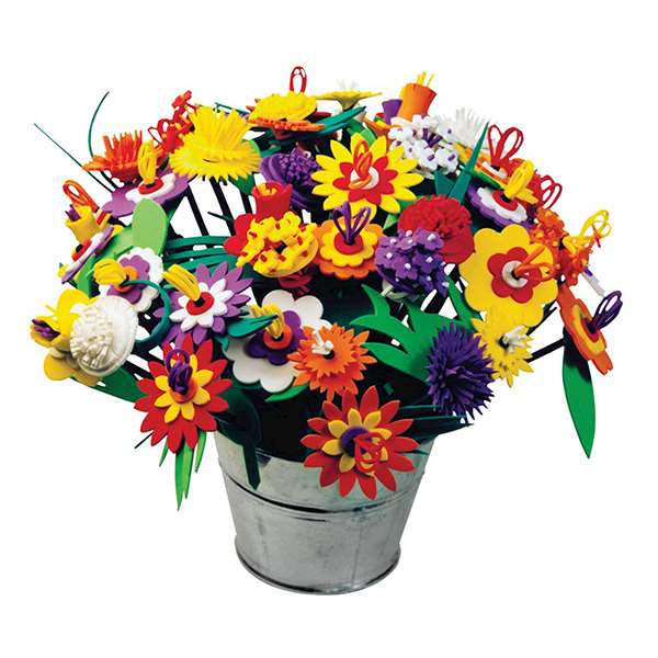 Vibrant multi-colored foam flowers with layered petals and green leaves in a small silver metal bucket.