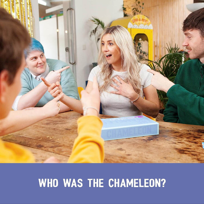 Three people point at a surprised woman sitting at a wooden table with a light blue patterned board game box.