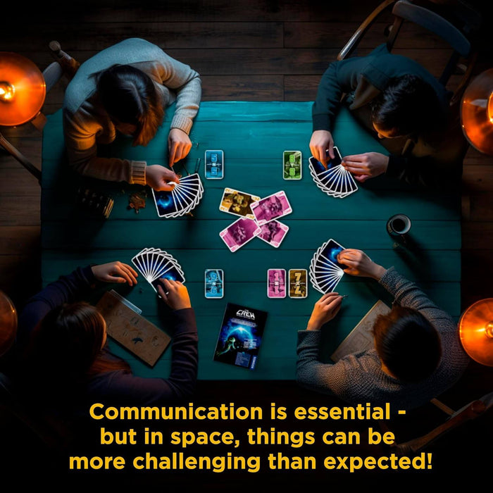 Top-down view of four people playing a space-themed card game at a teal table with cosmic cards and rulebook.