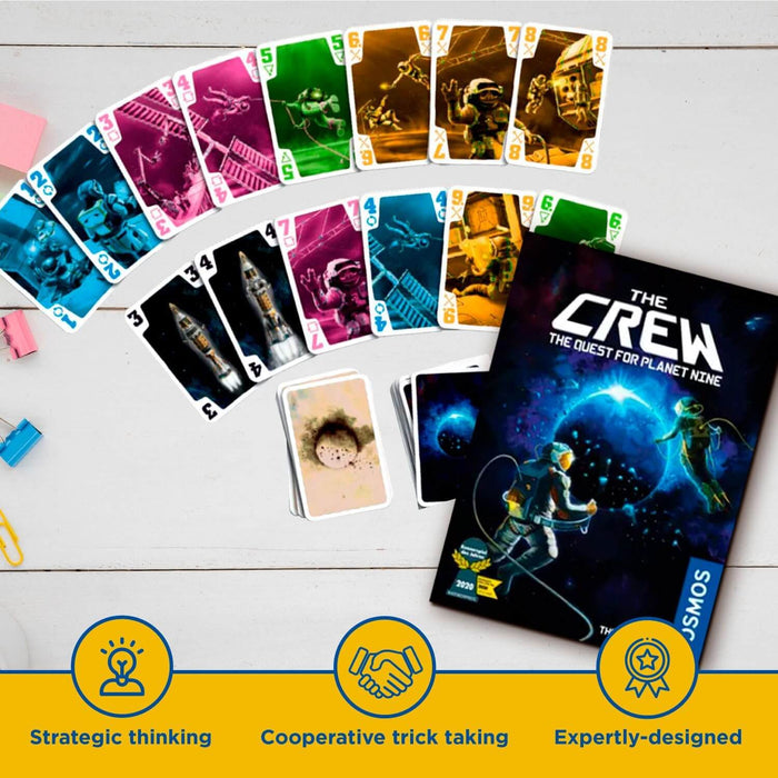 The Crew card game box and colorful space-themed cards on white wood with descriptive gameplay icons at the bottom.
