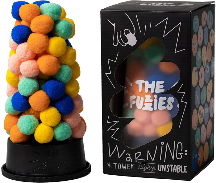 Tower of colorful fuzzy pom-poms on a black base next to a black box with cartoon illustrations and warning text.
