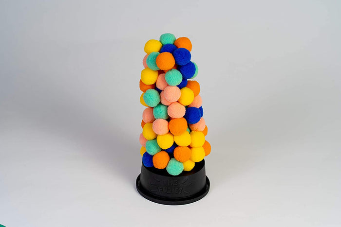A vertical tower of colorful, fuzzy pompoms in yellow, orange, blue, and green on a black circular base.