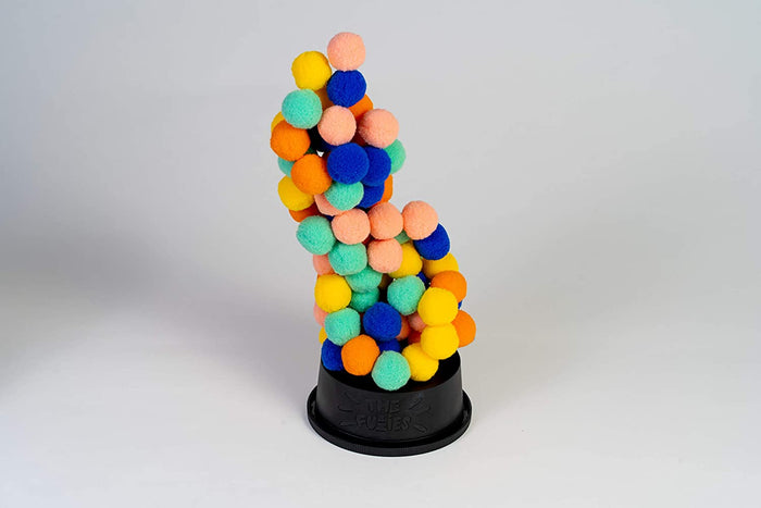 Precarious tower of pink, blue, orange, yellow, and green fuzzy balls stacked on a black container base with embossed logo.