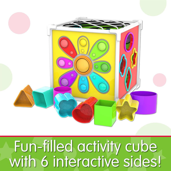 Colorful toy cube featuring a rainbow pop-it flower, shape sorter, and assorted colorful shape blocks in front.
