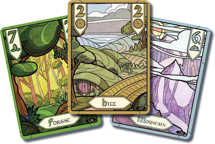 Three game cards with stained-glass style illustrations of a green forest, Hobbit-hole hills, and a purple mountain.