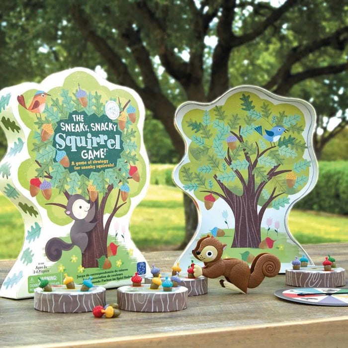 Tree-shaped box for a kids' board game with a brown squirrel squeezer, colorful plastic acorns, and log stump boards.