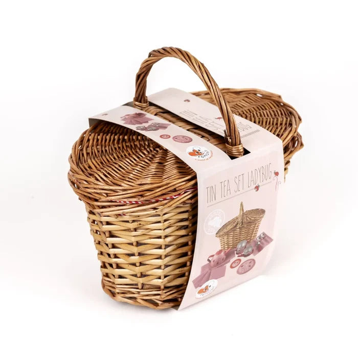 Small woven wicker basket with handle and pink product sleeve illustrating a ladybug-themed toy tea set.