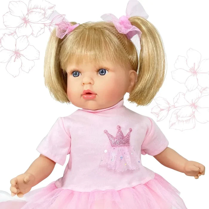 Blonde doll with pigtails and blue eyes wearing a pink shirt with a glitter crown and a pink tutu.