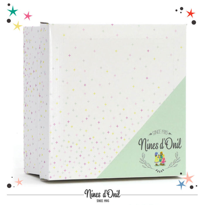 Square white and mint green box for Nines d'Onil dolls, featuring a pattern of colorful crosses and stars.