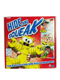 Red game box with a smiling yellow robot and illustrations of children hiding, finding, and building game pieces.