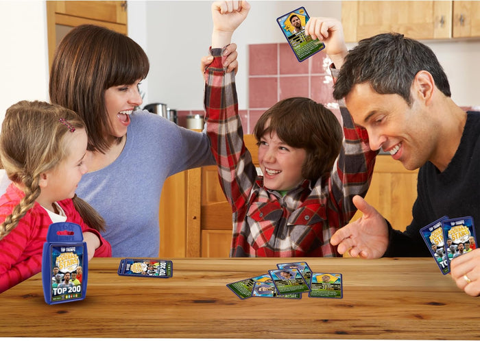 Family playing a football card game with blue plastic case and player stat cards on a wooden table.