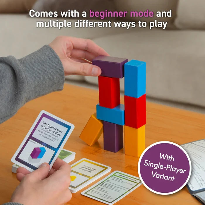 Hand placing a purple block atop a colorful tower of blue, red, and yellow bricks next to game cards.