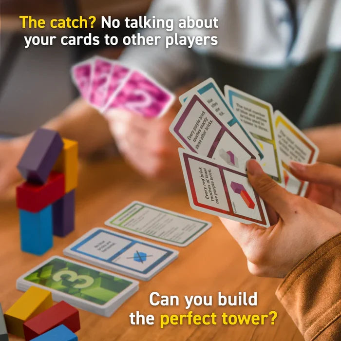 Hands holding rule cards next to a tower of purple, yellow, and blue wooden blocks on a wooden table.
