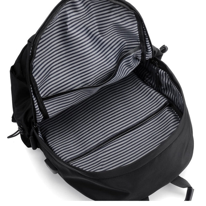 Grey travel backpack with USB charging port and water-resistant fabric, designed for carrying laptops and travel essentials.