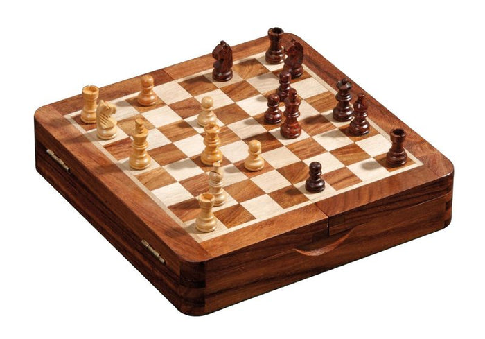 Small wooden travel chess set with light and dark magnetic pieces on a folding board that doubles as a storage case.