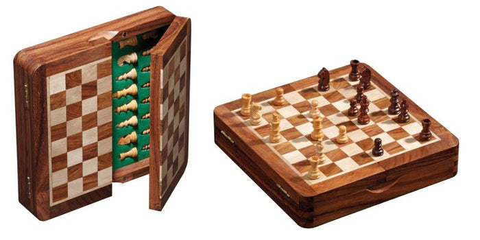Folding wooden chess set showing the checkered board with pieces and green felt-lined internal storage slots.