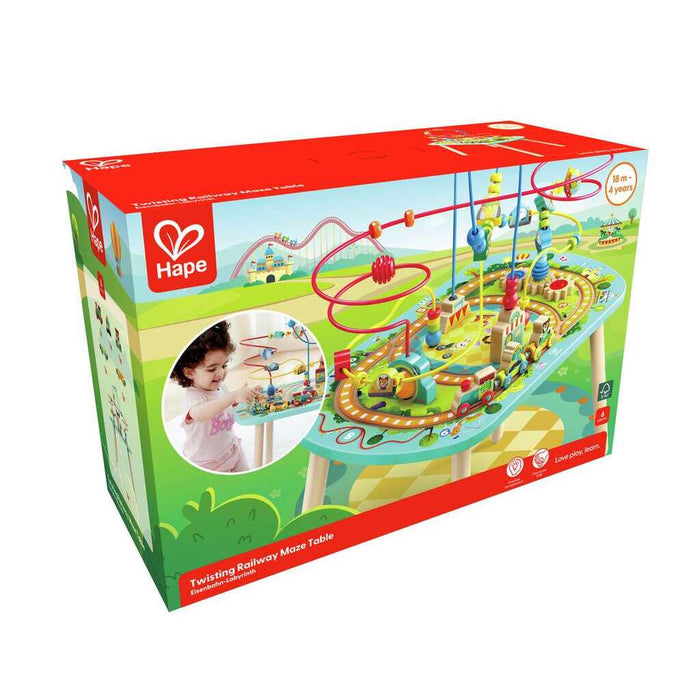 Red and green Hape box for a colorful activity table with train tracks and bead mazes, showing a child playing.